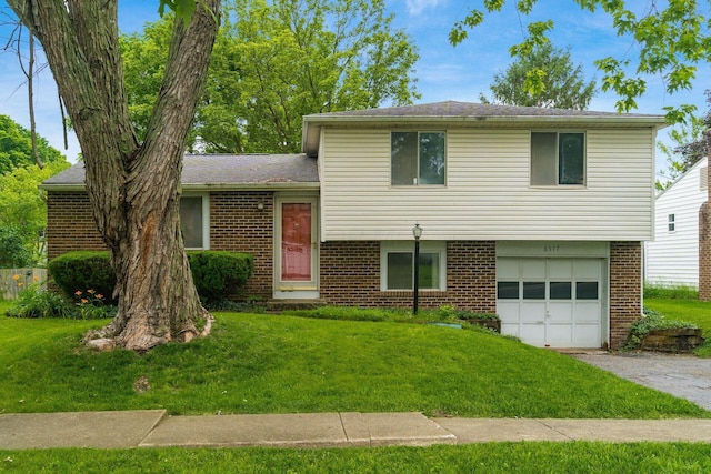 6517 Ponset St, Dublin, OH 43017 - tri-level home featuring brick siding, an attached garage, a front lawn, and driveway
