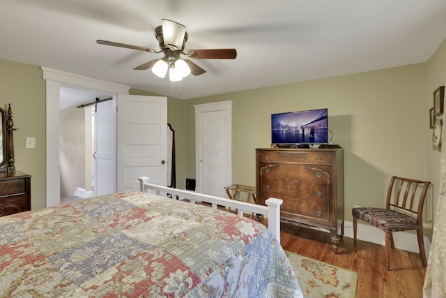 1350 Lancaster Kirkersville Rd NW, Lancaster, OH 43130 - bedroom with wood finished floors, a barn door, ceiling fan, and baseboards