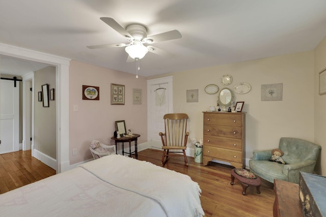 1350 Lancaster Kirkersville Rd NW, Lancaster, OH 43130 - bedroom featuring wood finished floors, baseboards, a barn door, and a ceiling fan