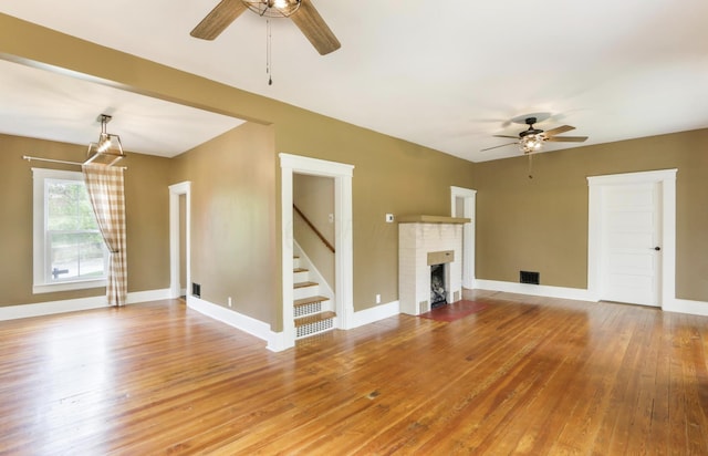 1350 Lancaster Kirkersville Rd NW, Lancaster, OH 43130 - unfurnished living room featuring a ceiling fan, hardwood / wood-style flooring, stairway, and a brick fireplace