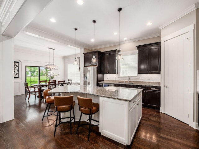 2462 Mccumber Ln, Lewis Center, OH 43035 - kitchen featuring stainless steel appliances, a kitchen island, a sink, decorative backsplash, and a breakfast bar