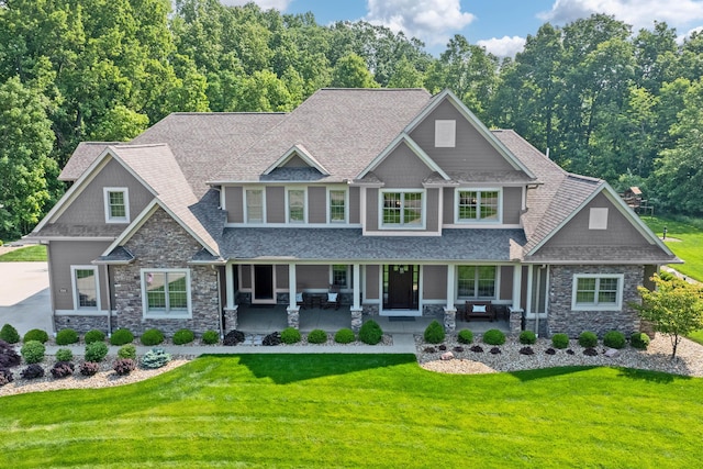 9568 Craigens Ct, Galena, OH 43021 - craftsman-style house with stone siding, roof with shingles, a front lawn, and covered porch