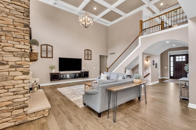 9568 Craigens Ct, Galena, OH 43021 - living room with arched walkways, a towering ceiling, stairway, baseboards, and a chandelier