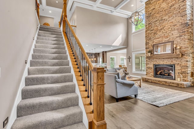 9568 Craigens Ct, Galena, OH 43021 - staircase featuring wood finished floors, a towering ceiling, coffered ceiling, beamed ceiling, and a fireplace