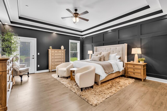 9568 Craigens Ct, Galena, OH 43021 - bedroom featuring a raised ceiling, a decorative wall, crown molding, light wood-style floors, and access to outside