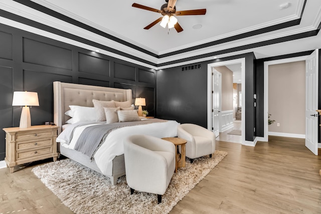 9568 Craigens Ct, Galena, OH 43021 - bedroom featuring a decorative wall, crown molding, light wood-type flooring, and a ceiling fan