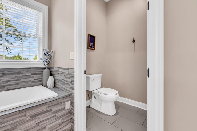 9568 Craigens Ct, Galena, OH 43021 - bathroom with a bath, toilet, tile patterned flooring, and baseboards