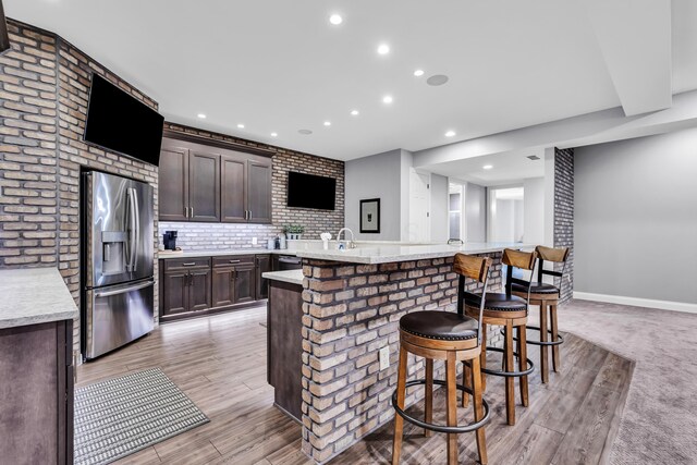 9568 Craigens Ct, Galena, OH 43021 - kitchen with stainless steel appliances, a breakfast bar area, dark brown cabinets, recessed lighting, and decorative backsplash