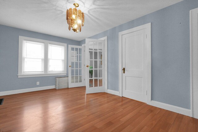 1936 Case Rd, Columbus, OH 43224 - spare room with baseboards, a chandelier, french doors, and wood finished floors