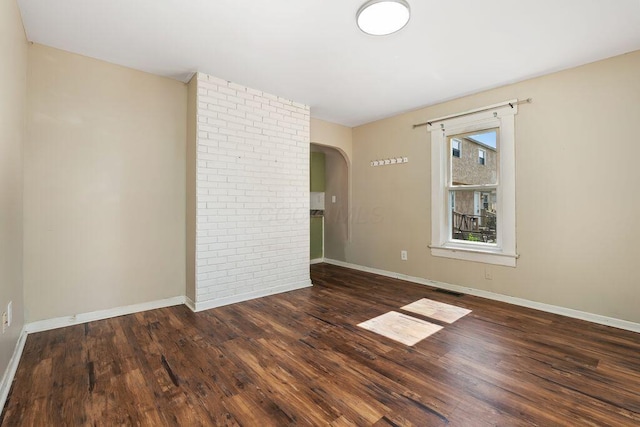 2165 Amherst Ave, Columbus, OH 43223 - empty room featuring arched walkways, wood finished floors, and baseboards