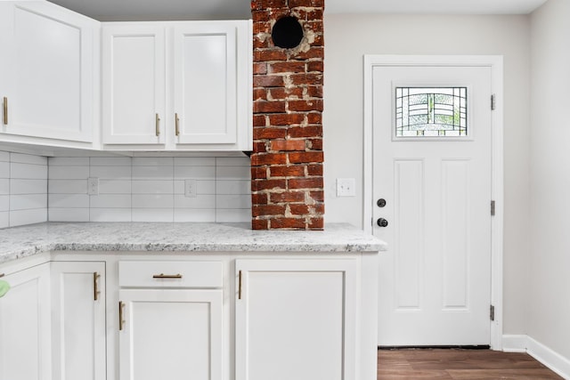 1805 Meriline Ave, Obetz, OH 43207 - kitchen featuring wood finished floors, tasteful backsplash, white cabinetry, light stone countertops, and baseboards
