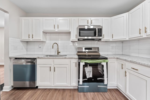 1805 Meriline Ave, Obetz, OH 43207 - kitchen featuring appliances with stainless steel finishes, a sink, light wood finished floors, and white cabinetry