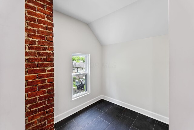 1805 Meriline Ave, Obetz, OH 43207 - empty room featuring dark tile patterned floors, baseboards, and vaulted ceiling