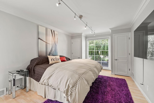 195 S Gould Rd, Columbus, OH 43209 - bedroom featuring track lighting, ornamental molding, light wood-type flooring, and baseboards