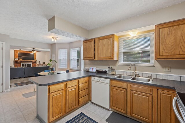 6897 Roundelay Rd N, Reynoldsburg, OH 43068 - kitchen featuring white dishwasher, a sink, a peninsula, dark countertops, and a textured ceiling