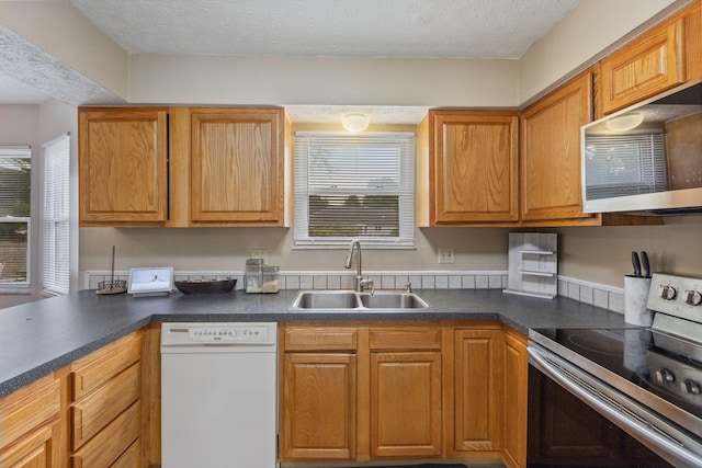 6897 Roundelay Rd N, Reynoldsburg, OH 43068 - kitchen with white dishwasher, stainless steel range with electric cooktop, a sink, plenty of natural light, and a textured ceiling