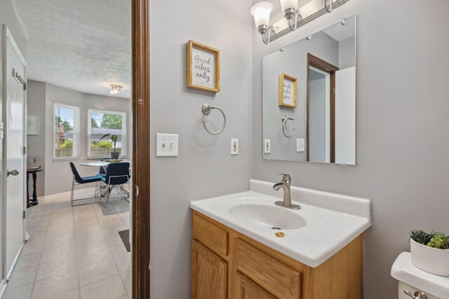 6897 Roundelay Rd N, Reynoldsburg, OH 43068 - bathroom featuring vanity, toilet, baseboards, and a textured ceiling