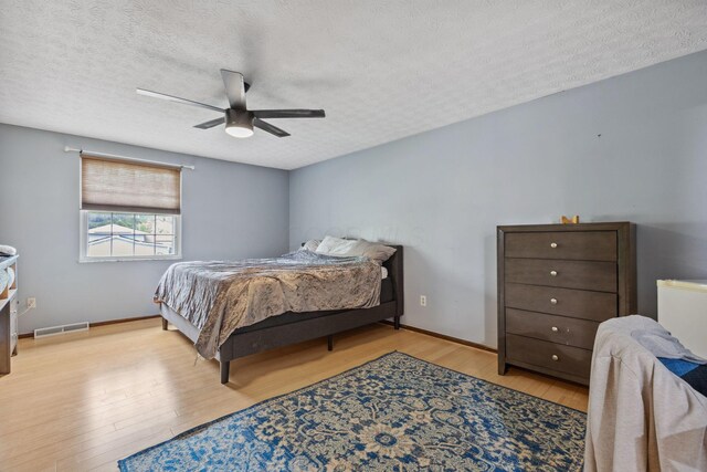 6897 Roundelay Rd N, Reynoldsburg, OH 43068 - bedroom with light wood finished floors, a textured ceiling, and a ceiling fan