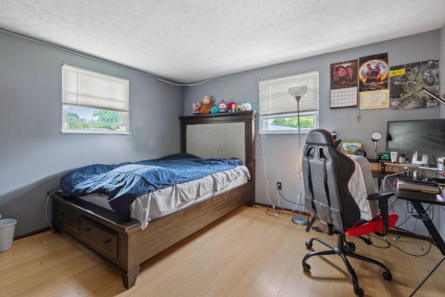 6897 Roundelay Rd N, Reynoldsburg, OH 43068 - bedroom with wood finished floors, a textured ceiling, an office area, and baseboards