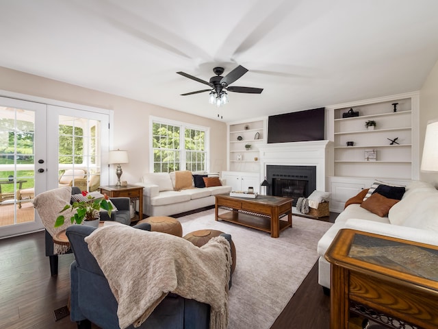 2870 Tarkman Dr, Nashport, OH 43830 - living room with a ceiling fan, french doors, a glass covered fireplace, dark wood-style flooring, and built in shelves