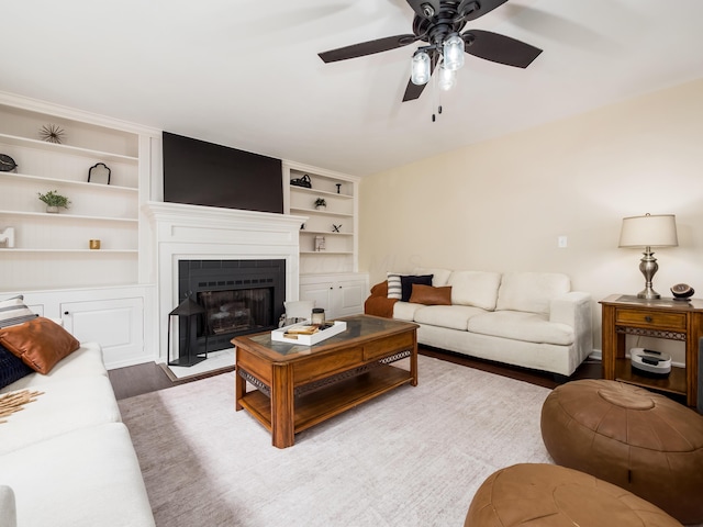 2870 Tarkman Dr, Nashport, OH 43830 - living room with ceiling fan, wood finished floors, built in shelves, and a fireplace with flush hearth