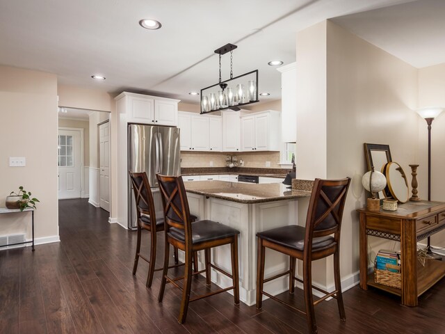 2870 Tarkman Dr, Nashport, OH 43830 - kitchen featuring a breakfast bar area, a peninsula, dark wood-style floors, freestanding refrigerator, and recessed lighting