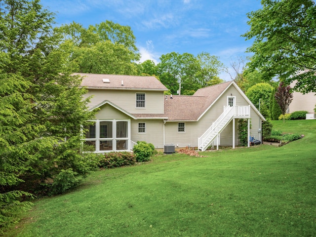 2870 Tarkman Dr, Nashport, OH 43830 - back of property with stairs, a sunroom, central AC, a lawn, and roof with shingles