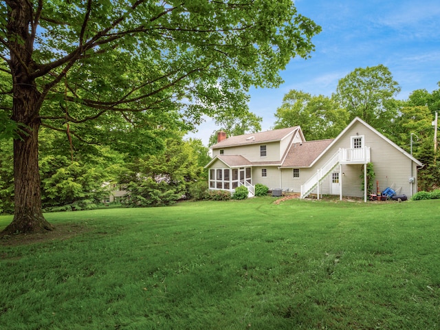 2870 Tarkman Dr, Nashport, OH 43830 - rear view of property with a lawn, a sunroom, a chimney, and roof with shingles