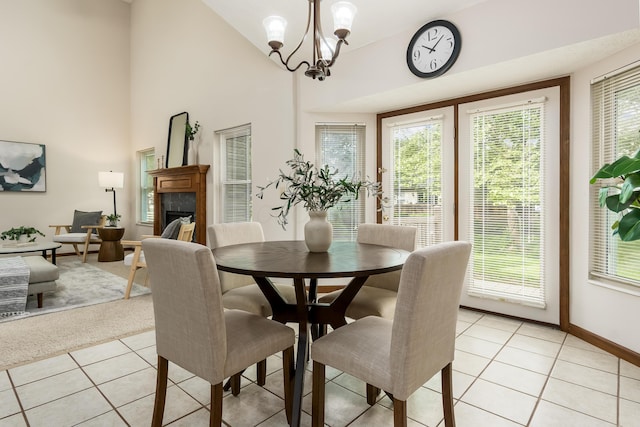 5839 Castleknock Rd, Dublin, OH 43016 - dining room with light tile patterned flooring, a chandelier, baseboards, a tile fireplace, and vaulted ceiling
