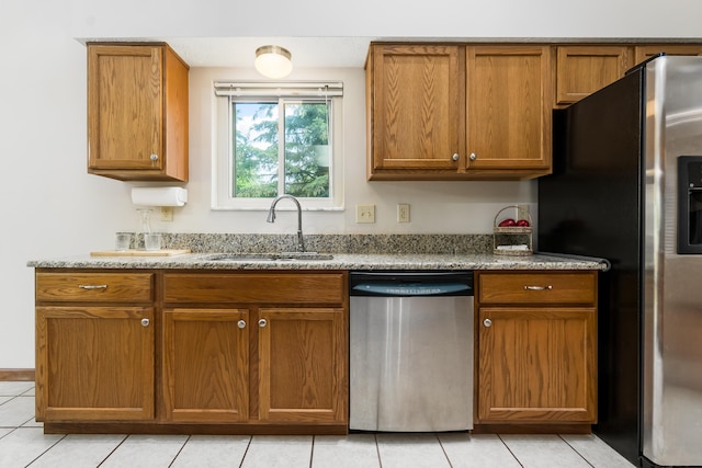 5839 Castleknock Rd, Dublin, OH 43016 - kitchen featuring appliances with stainless steel finishes, a sink, brown cabinets, and light tile patterned flooring
