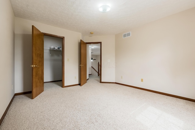 5839 Castleknock Rd, Dublin, OH 43016 - unfurnished bedroom with a textured ceiling, light carpet, baseboards, a closet, and a spacious closet