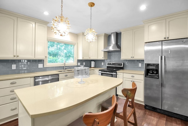 4558 Crompton Dr, Columbus, OH 43220 - kitchen featuring stainless steel appliances, wall chimney exhaust hood, cream cabinets, dark wood-type flooring, and recessed lighting
