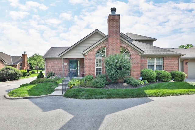 880 Village Brook Way, Columbus, OH 43235 - view of front facade featuring brick siding, a chimney, a shingled roof, a garage, and a front yard