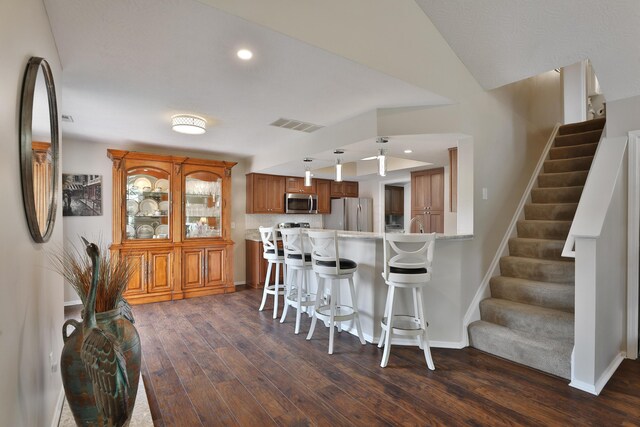 880 Village Brook Way, Columbus, OH 43235 - kitchen with stainless steel microwave, brown cabinetry, freestanding refrigerator, fridge, and dark wood finished floors