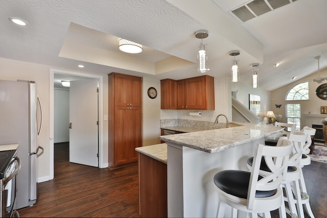 880 Village Brook Way, Columbus, OH 43235 - kitchen featuring brown cabinetry, dark wood-style floors, appliances with stainless steel finishes, a peninsula, and a breakfast bar area