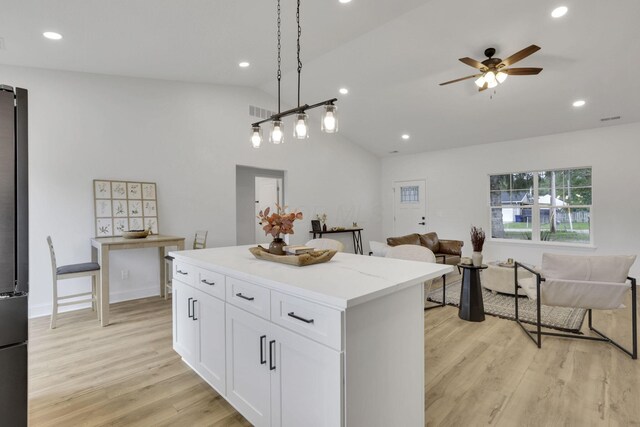 13081 Dogwood Rd NE, Thornville, OH 43076 - kitchen with lofted ceiling, a center island, white cabinetry, light wood-type flooring, and open floor plan