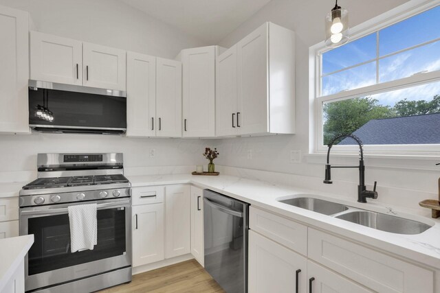 13081 Dogwood Rd NE, Thornville, OH 43076 - kitchen with appliances with stainless steel finishes, a sink, white cabinetry, light stone countertops, and vaulted ceiling