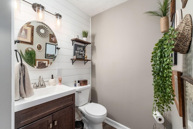 7765 Lantana Ave Unit 164, Blacklick, OH 43004 - half bathroom featuring vanity, toilet, wood walls, and a textured ceiling