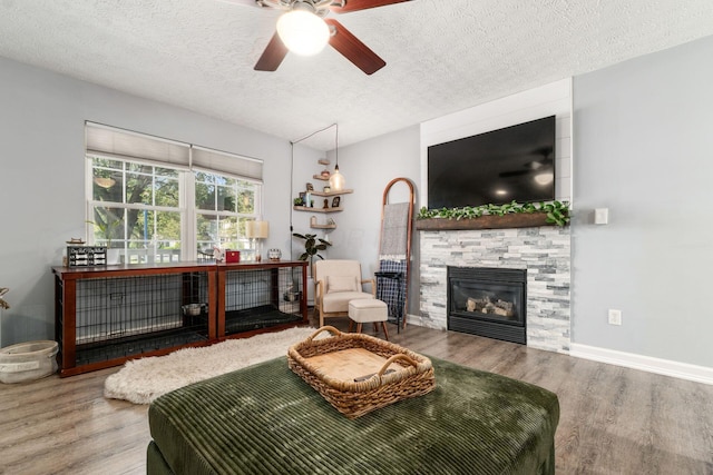 7765 Lantana Ave Unit 164, Blacklick, OH 43004 - living room with a fireplace, wood finished floors, a textured ceiling, a ceiling fan, and baseboards
