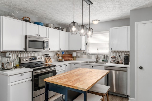 7765 Lantana Ave Unit 164, Blacklick, OH 43004 - kitchen with stainless steel appliances, a sink, light countertops, white cabinetry, and decorative light fixtures