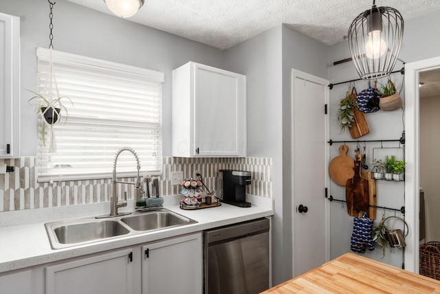7765 Lantana Ave Unit 164, Blacklick, OH 43004 - kitchen with stainless steel dishwasher, a sink, white cabinetry, backsplash, and a textured ceiling