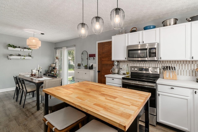 7765 Lantana Ave Unit 164, Blacklick, OH 43004 - kitchen featuring appliances with stainless steel finishes, white cabinets, wood finished floors, a textured ceiling, and decorative backsplash