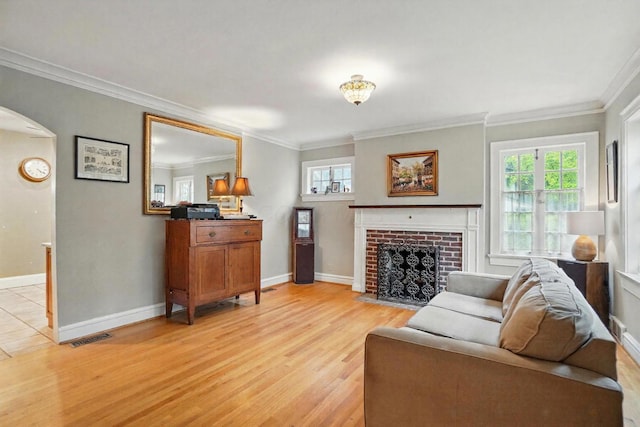 1875 King Ave, Columbus, OH 43212 - living room with arched walkways, light wood finished floors, ornamental molding, baseboards, and a brick fireplace