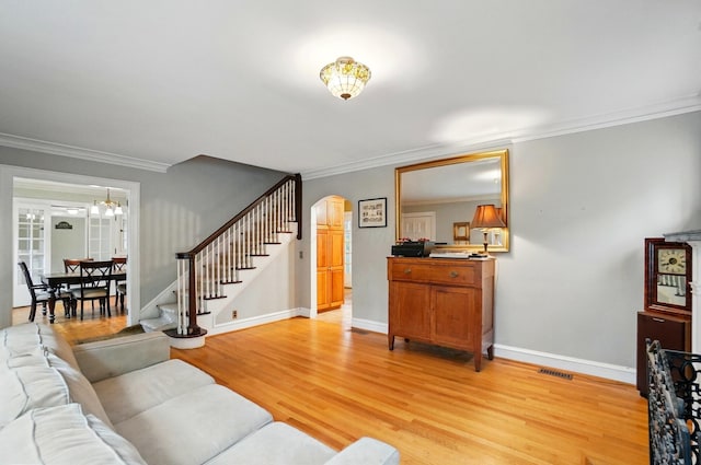 1875 King Ave, Columbus, OH 43212 - living area with stairs, arched walkways, light wood-style flooring, crown molding, and baseboards