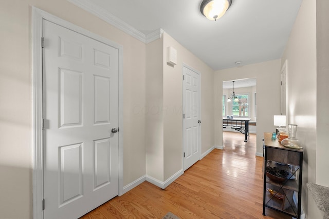 13682 Cobblestone Ln, Pickerington, OH 43147 - hall featuring light wood finished floors, baseboards, crown molding, and a chandelier