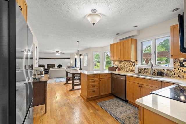 13682 Cobblestone Ln, Pickerington, OH 43147 - kitchen featuring stainless steel dishwasher, a sink, a peninsula, freestanding refrigerator, and open floor plan