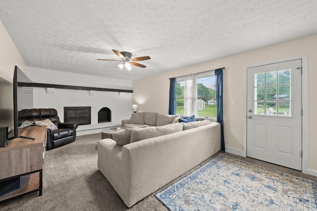 13682 Cobblestone Ln, Pickerington, OH 43147 - living room with ceiling fan, a brick fireplace, carpet flooring, baseboards, and a textured ceiling
