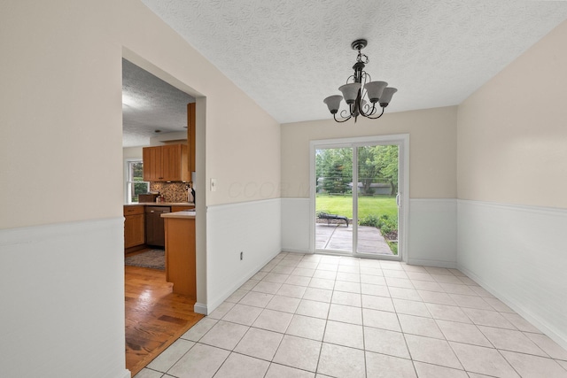 13682 Cobblestone Ln, Pickerington, OH 43147 - unfurnished dining area featuring a chandelier, a textured ceiling, and light tile patterned flooring