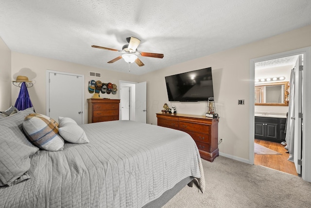 13682 Cobblestone Ln, Pickerington, OH 43147 - bedroom featuring light carpet, ceiling fan, connected bathroom, baseboards, and a textured ceiling