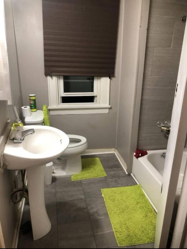1403 Genessee Ave, Columbus, OH 43211 - full bathroom with baseboards, toilet, tile patterned flooring, tub / shower combination, and a sink